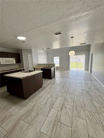 a large kitchen with stainless steel appliances a large counter top a stove a sink dishwasher and a refrigerator