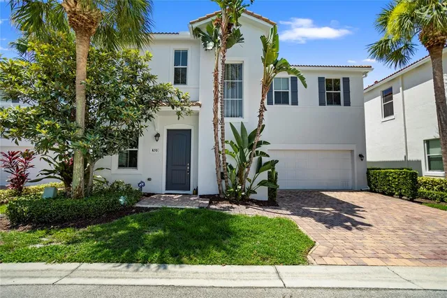 a front view of a house with a yard and palm trees