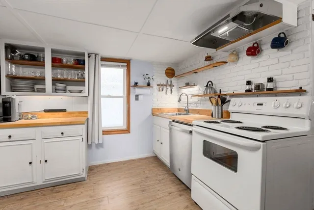 a kitchen with a stove and white cabinets
