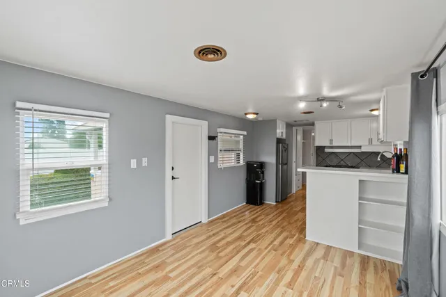 a kitchen with a refrigerator and a wooden floor
