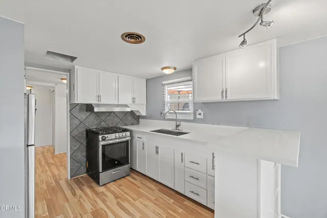 a kitchen with stainless steel appliances granite countertop a stove and a sink