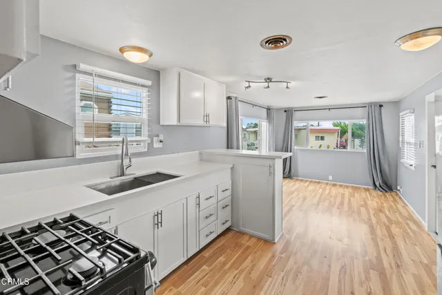 a kitchen with a sink and wooden floor