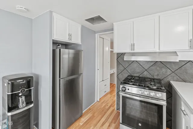 a kitchen with a stove top oven and refrigerator