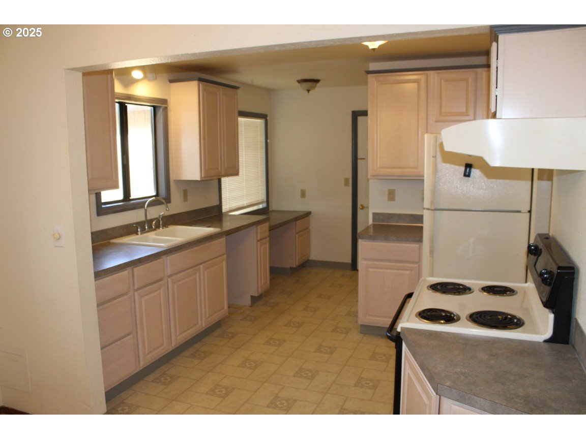 1206 Southwest 24th Street Pendleton, OR 97801 - Photo 7 of 21 a kitchen with a sink stove and refrigerator