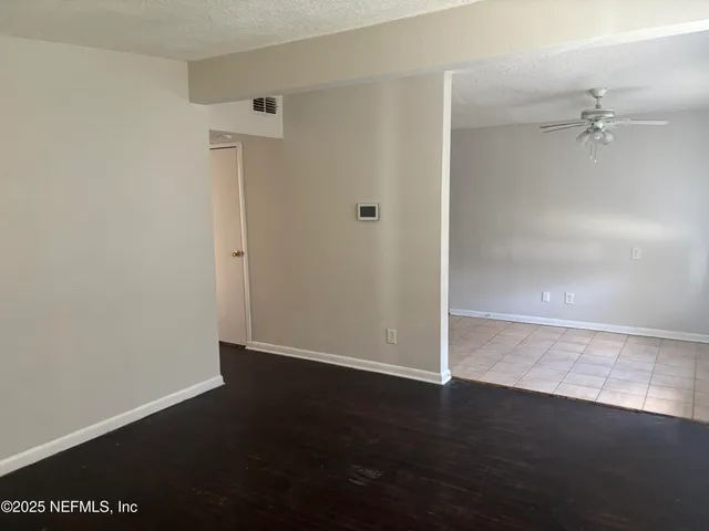 an empty room with wooden floor and cabinet