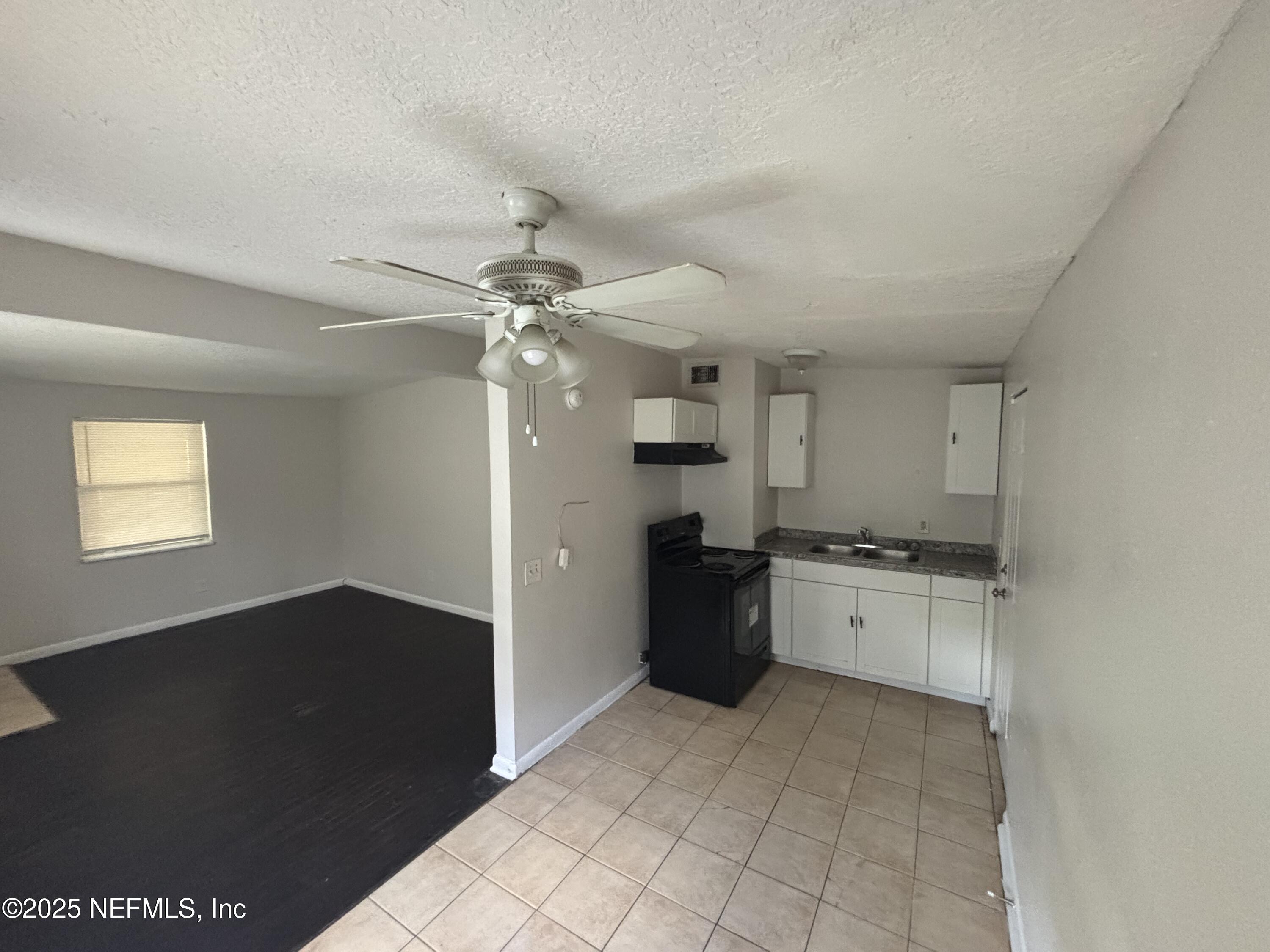 4225 Homer Road North Jacksonville, FL 32209 - Photo 6 of 11 a kitchen with granite countertop a refrigerator and a stove top oven