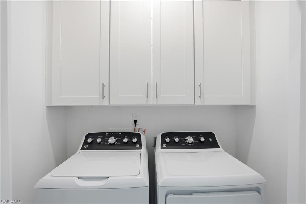 1 Fairview Boulevard Fort Myers Beach, FL 33931 - Photo 22 of 48 Dedicated laundry space featuring upper white cabinetry with brushed nickel hardware - Virtually Edited Image