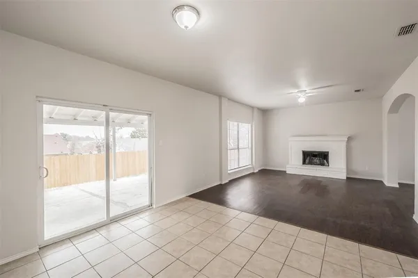 a view of an empty room with window and wooden floor