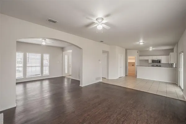 wooden floor in an empty room with a kitchen