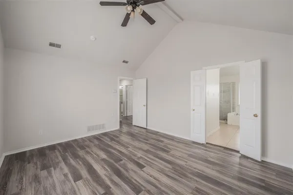 a view of a room with wooden floor and a ceiling fan