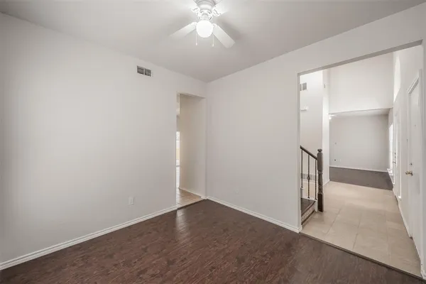 an empty room with a ceiling fan and entryway