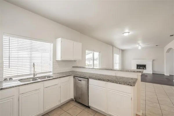 a kitchen with granite countertop white cabinets and white appliances