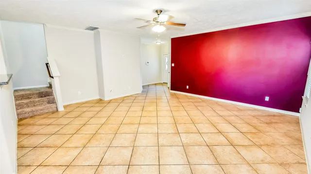 a view of a livingroom with wooden floor and a chandelier fan