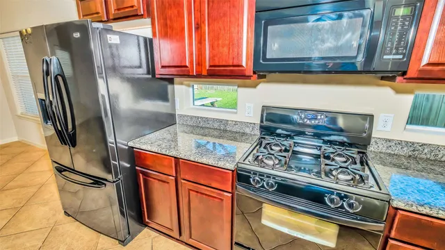 a kitchen with stainless steel appliances granite countertop a refrigerator and a stove