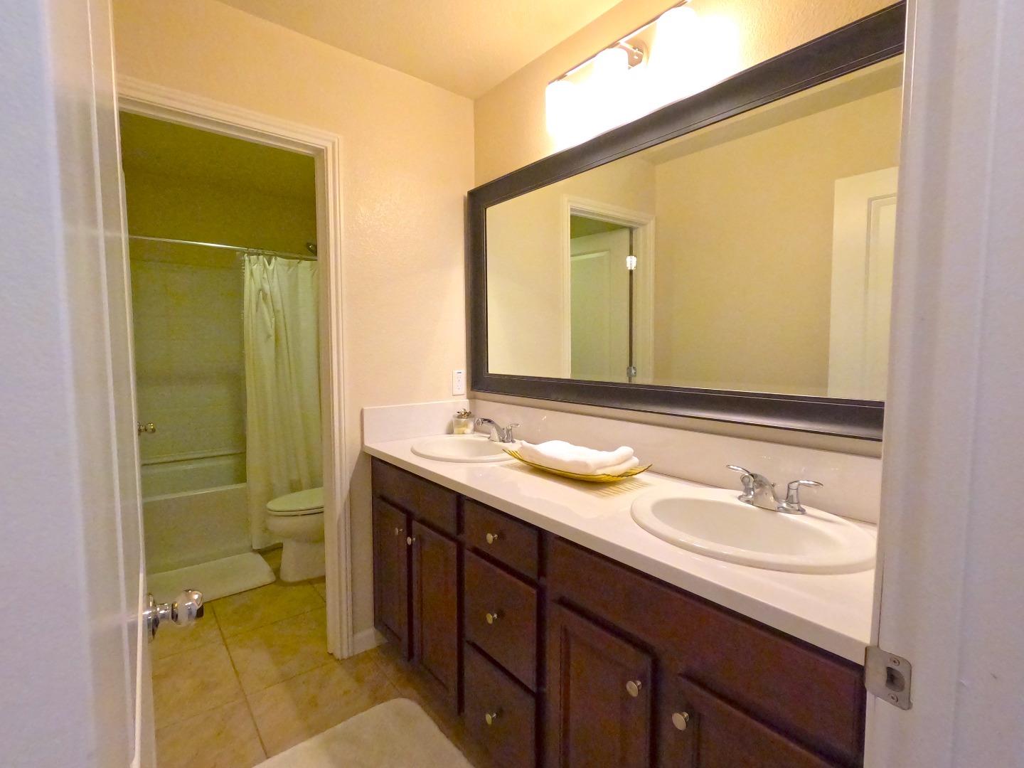 13217 Thomas Lane Marina, CA 93933 - Photo 19 of 35 a bathroom with a granite countertop sink mirror and a toilet