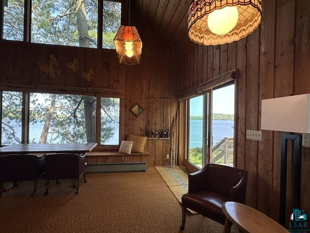 2763 Van Vac Road Ely, MN 55731 - Photo 5 of 37 Wood-paneled interior featuring expansive glass windows and a sliding glass door offering direct water scenery