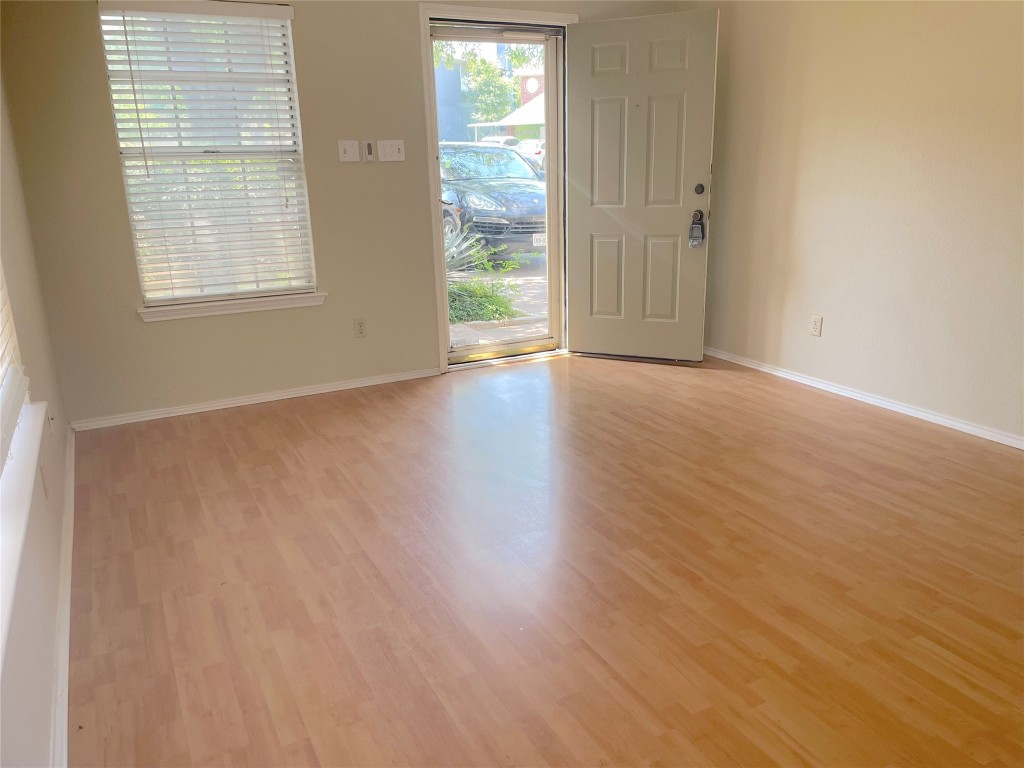 8501 Bismark Cove Austin, TX 78745 - Photo 3 of 24 an empty room with wooden floor and windows