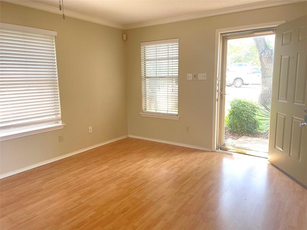 8501 Bismark Cove Austin, TX 78745 - Photo 4 of 24 a view of an empty room with wooden floor and a window