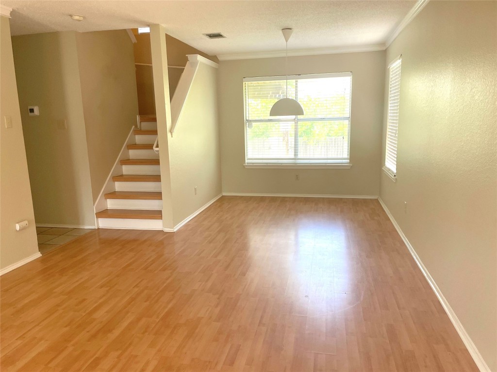 8501 Bismark Cove Austin, TX 78745 - Photo 6 of 24 an empty room with wooden floor and windows