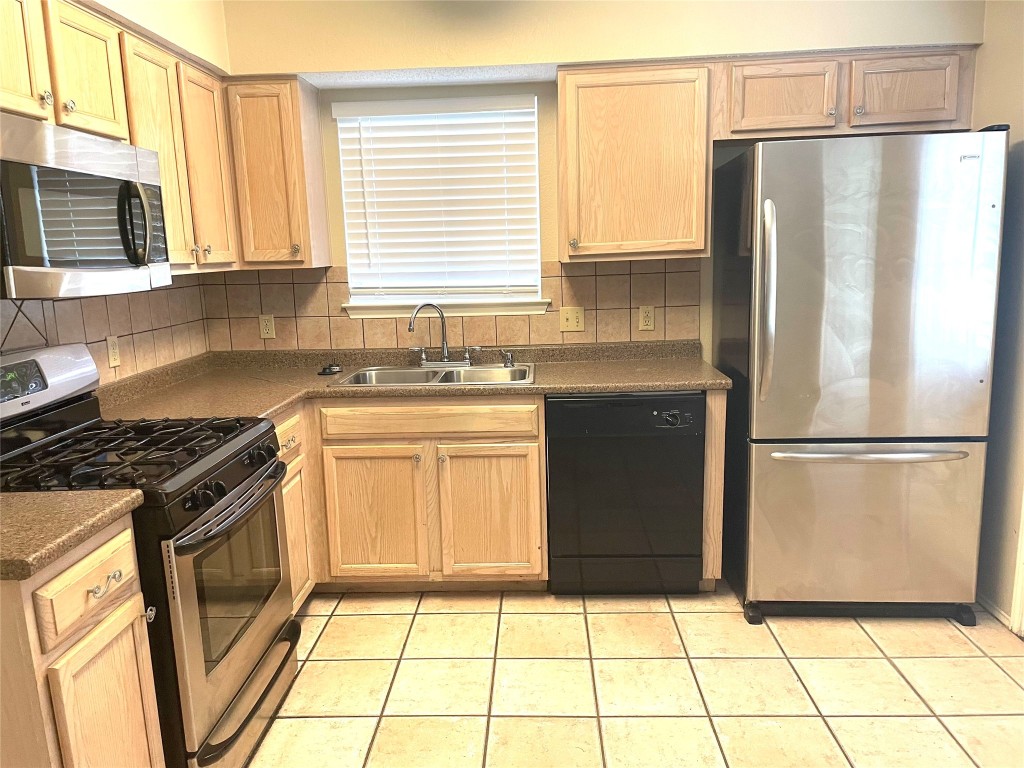 8501 Bismark Cove Austin, TX 78745 - Photo 9 of 24 a kitchen with granite countertop a refrigerator sink stove and microwave