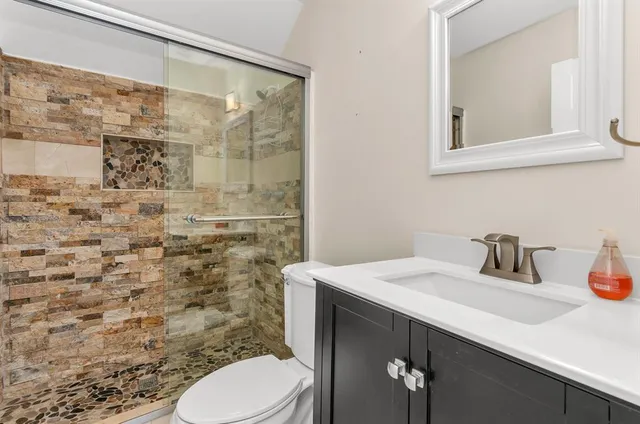 a bathroom with a sink a toilet and shower