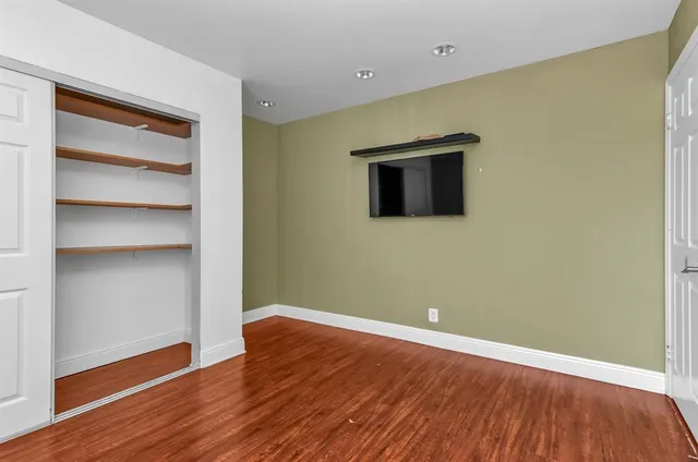 a view of an empty room with wooden floor