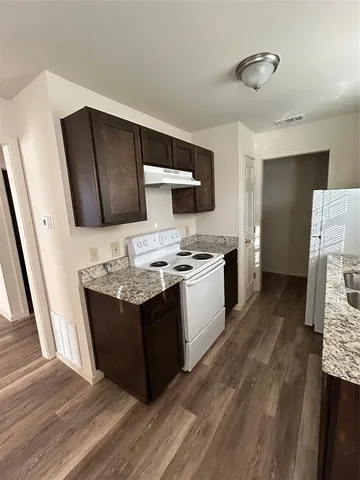 a kitchen with stainless steel appliances granite countertop a stove and a refrigerator