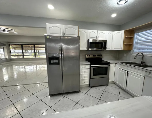a kitchen with stainless steel appliances granite countertop a stove a sink and a refrigerator
