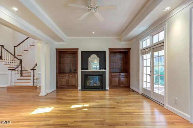 a view of a room with wooden floor fan and windows