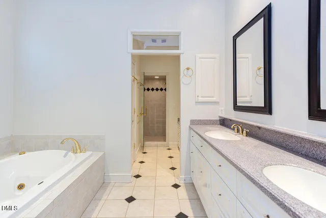 a bathroom with a tub sink and mirror