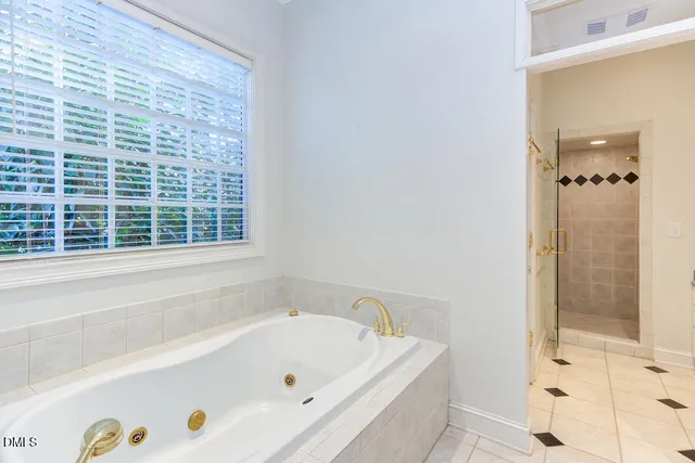 a bathroom with a tub a window and a shower