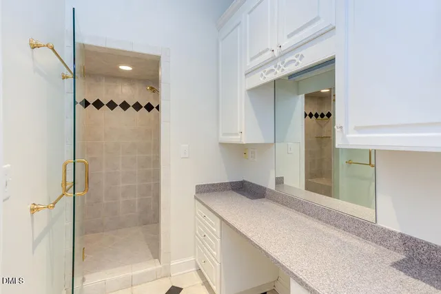a bathroom with a granite countertop sink mirror and shower