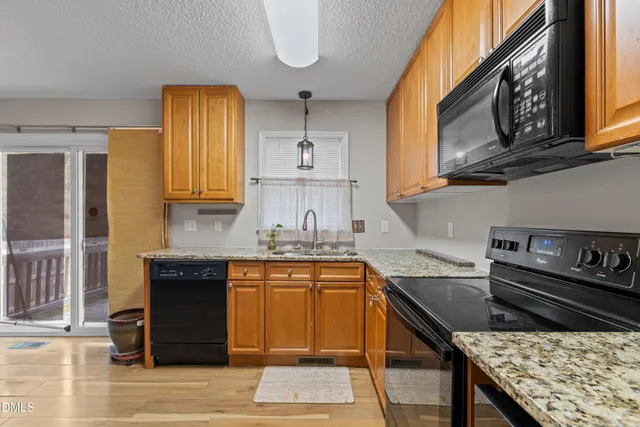 a kitchen with granite countertop a sink stove and refrigerator