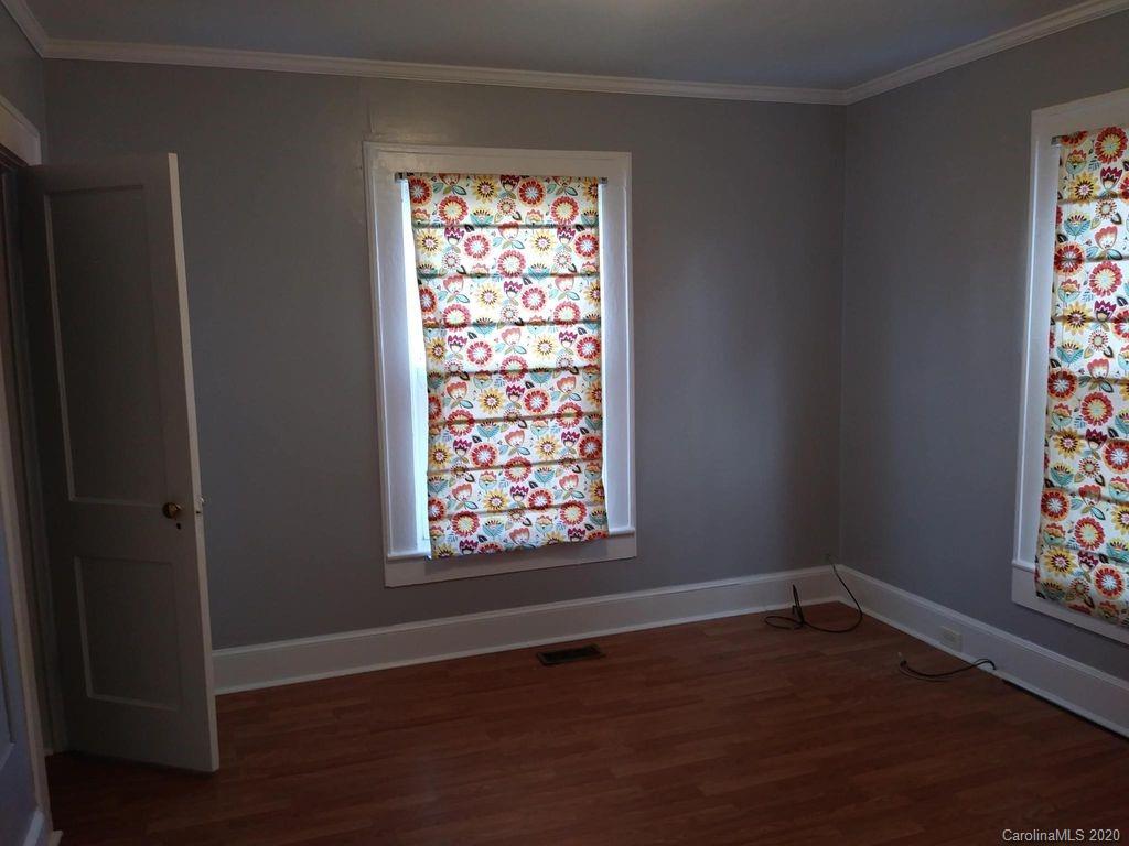 1002 South Ridge Avenue Kannapolis, NC 28083 - Photo 5 of 9 an empty room with wooden floor and windows