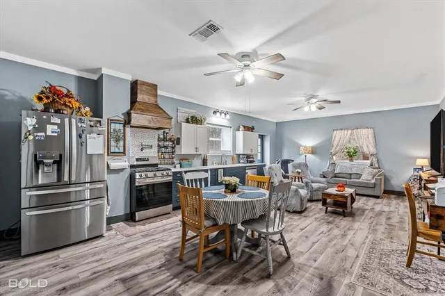 a dining room with furniture a rug a potted plant and a chandelier