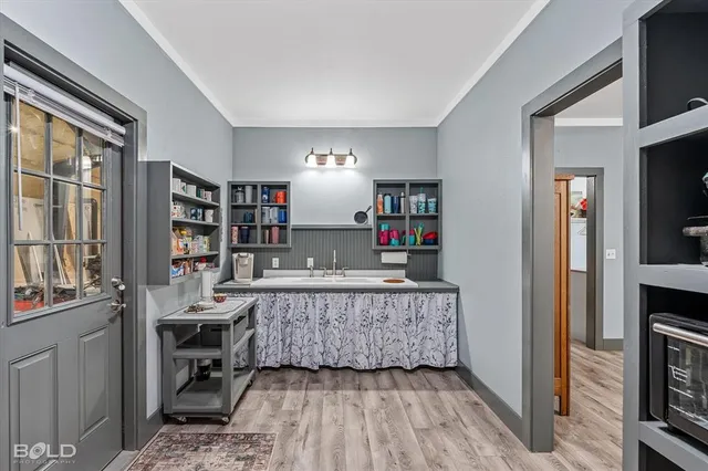 a view of empty room with wooden floor and book shelf