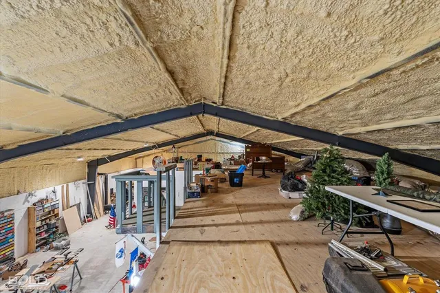 an empty room with a chandelier fan and windows