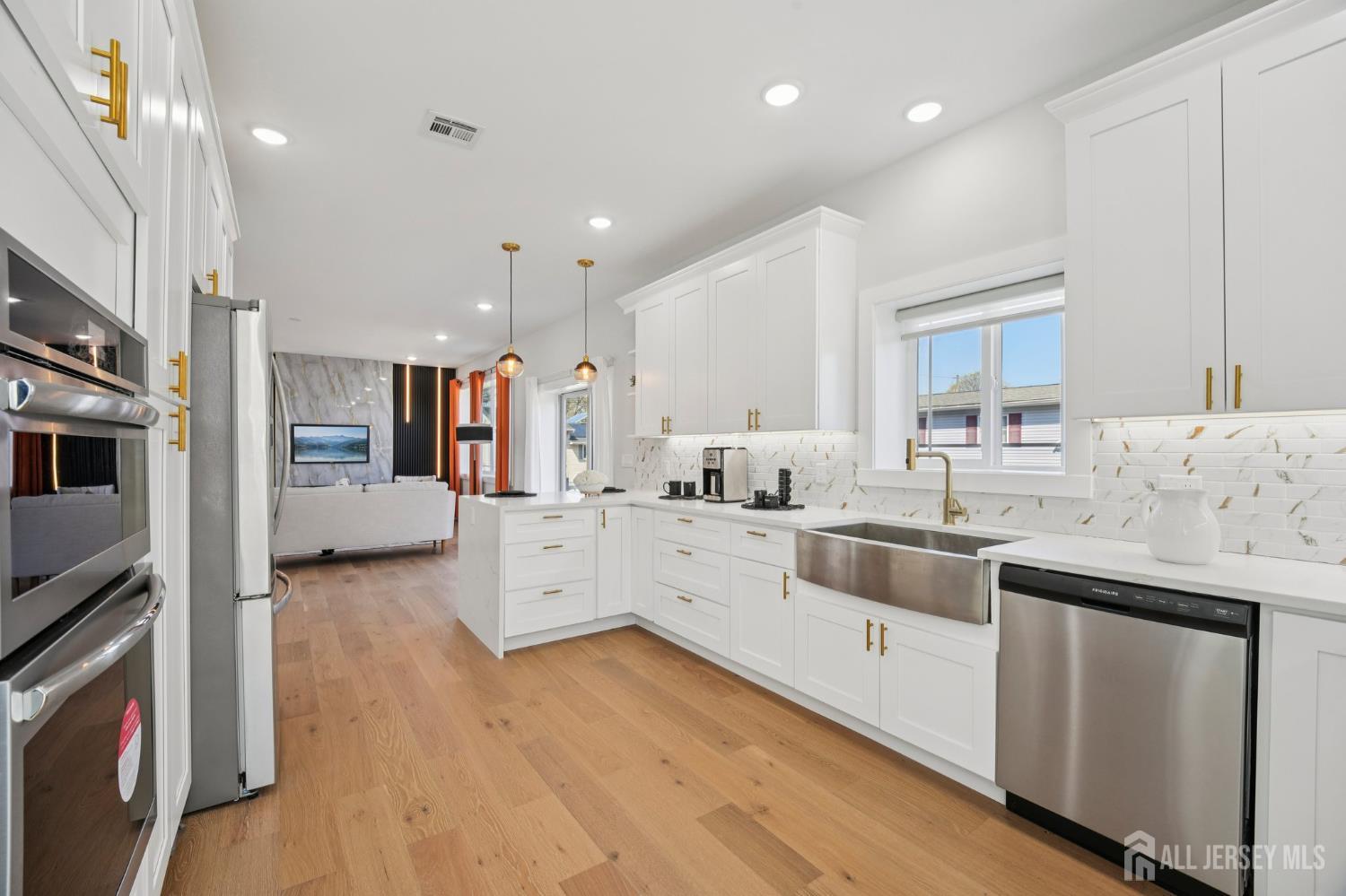 75 Jefferson Boulevard Edison, NJ 08817 - Photo 16 of 75 a large white kitchen with a stove a sink a refrigerator and white cabinets with wooden floor
