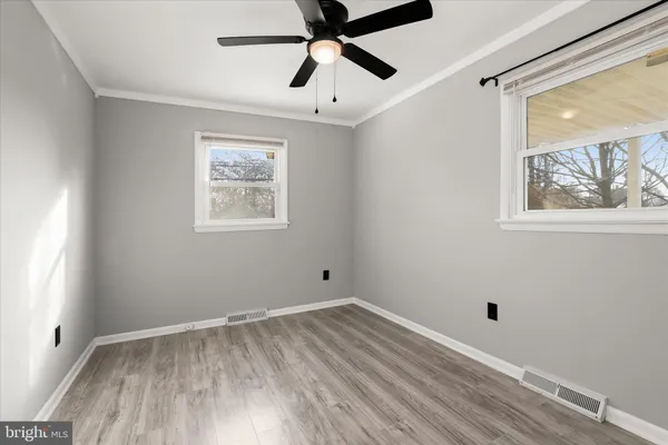 a view of empty room with wooden floor and window