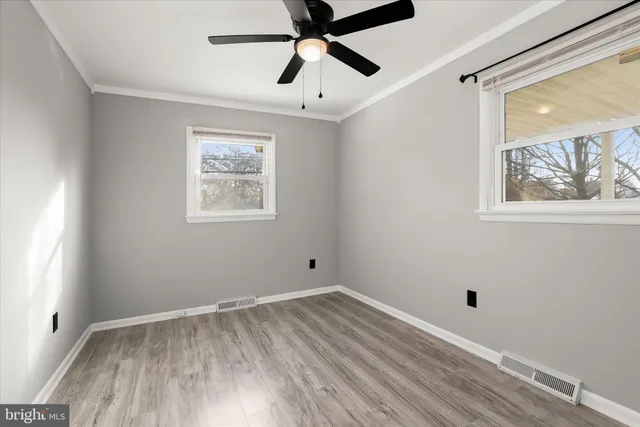 a view of empty room with wooden floor and window