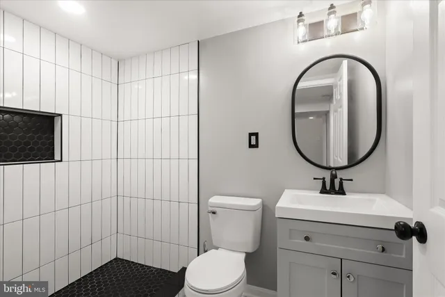 a bathroom with a sink a toilet and a mirror