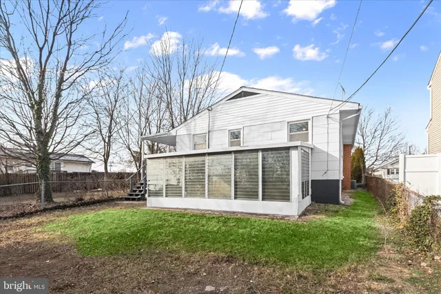 a view of a house with a yard and large tree