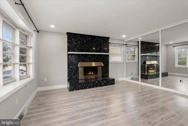 a view of an empty room with a fireplace and a window