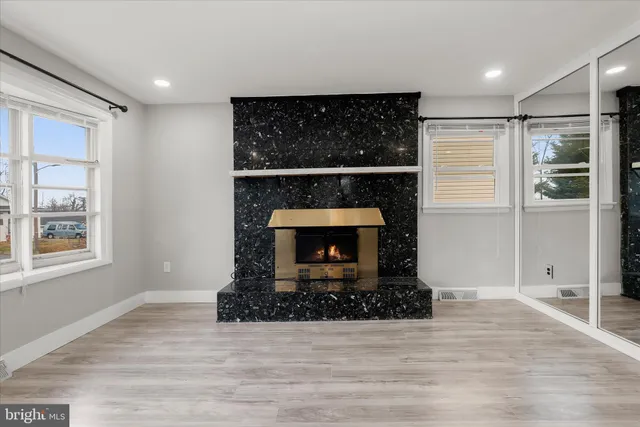a living room with a fireplace and a wooden floor