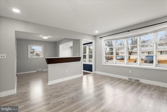 a large hall with wooden floor and windows