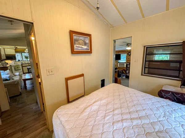 a bedroom with a bed and a dresser with wooden floor