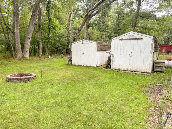a backyard of a house with table and chairs and a large tree