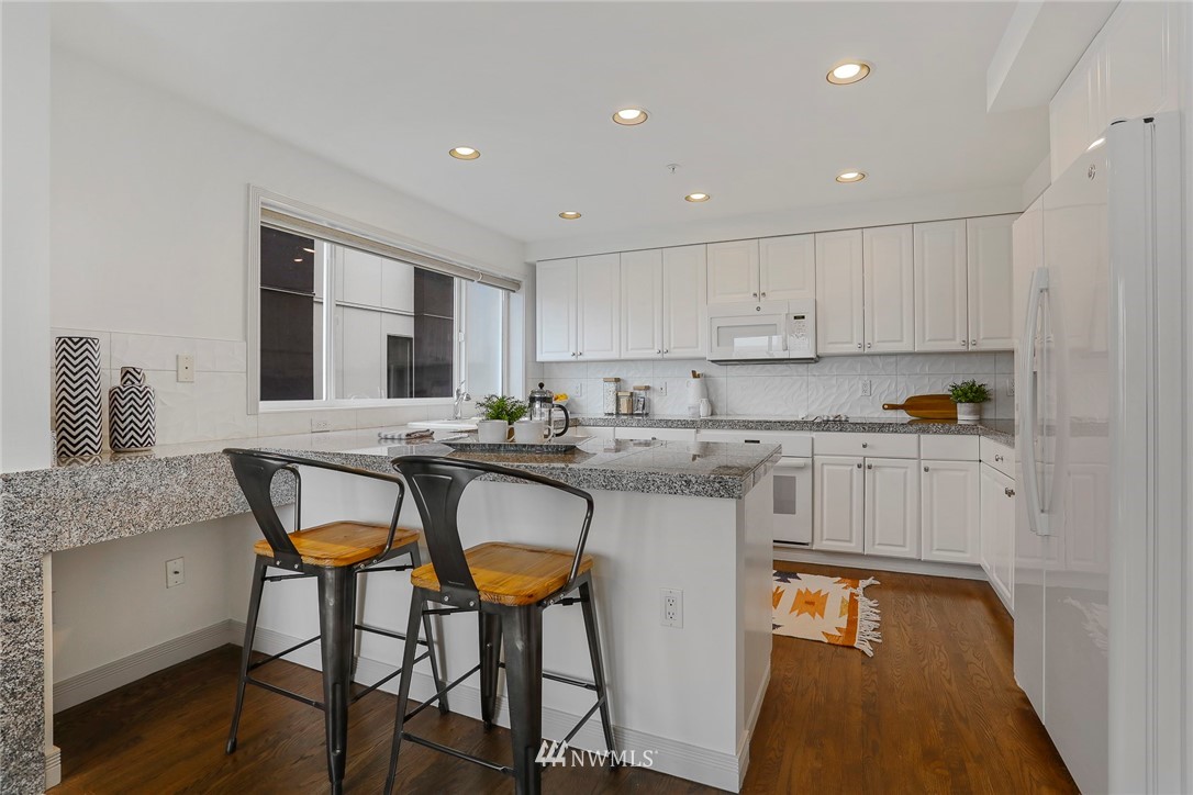 601 West Mercer Place, Unit 201 Seattle, WA 98119 - Photo 12 of 36 a kitchen with stainless steel appliances granite countertop a stove a sink and a refrigerator