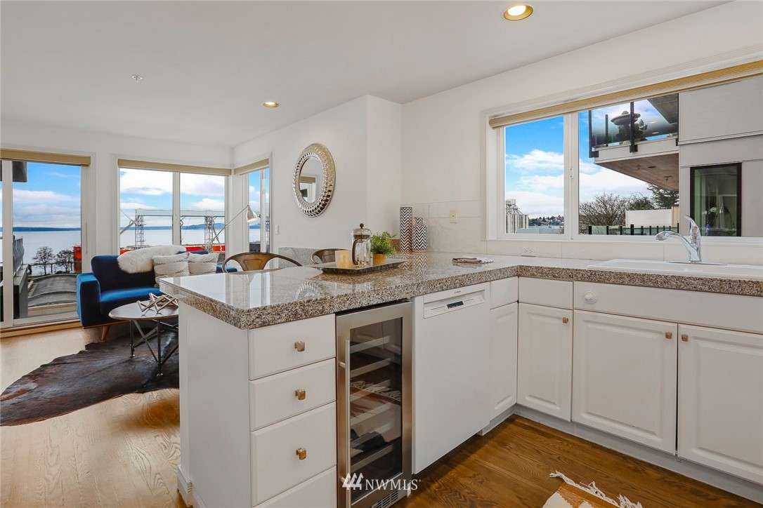 601 West Mercer Place, Unit 201 Seattle, WA 98119 - Photo 15 of 36 a open kitchen with granite countertop a sink and dishwasher with white cabinets