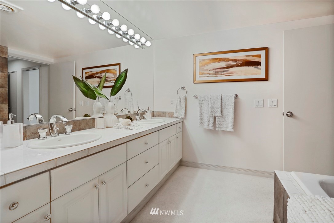 601 West Mercer Place, Unit 201 Seattle, WA 98119 - Photo 23 of 36 a bathroom with a double vanity sink and a mirror